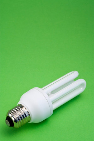 energy saving lamp on green background with copyspace