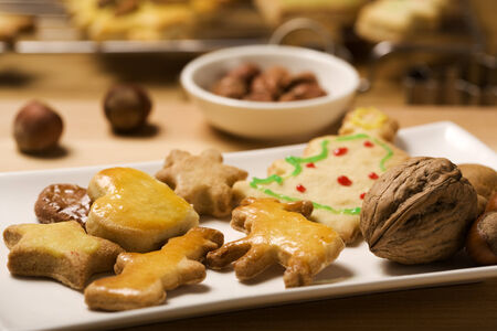 handmade christmas cookies on a plate, nuts in backgroundの写真素材