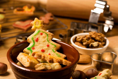 cookies in a bowl, christmas tree shape in focus, baking utensils in backgroundの写真素材