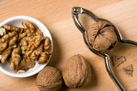 nutcracker, walnuts in and around bowl