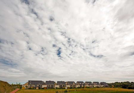 cloudscape above row of suburban homesの写真素材