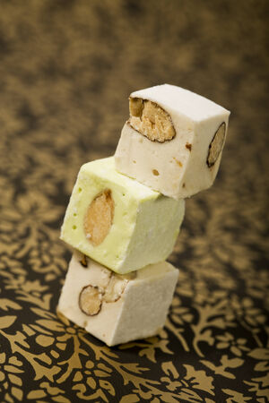 Three turron nougat confection blocks stacked on an ornamental golden surface. Turron is a typical christmas dessert in Spain and Latin America as well as in Italy, where it is called Torroneの写真素材