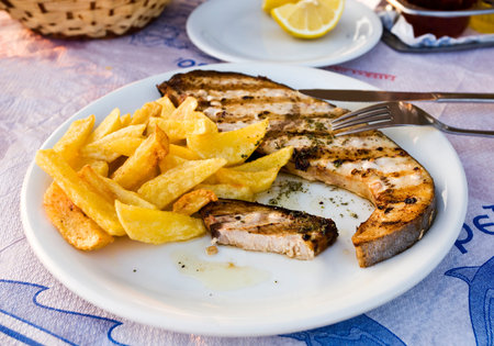 greek cuisine - grilled swordfish fillet with herbs and potato chipsの写真素材