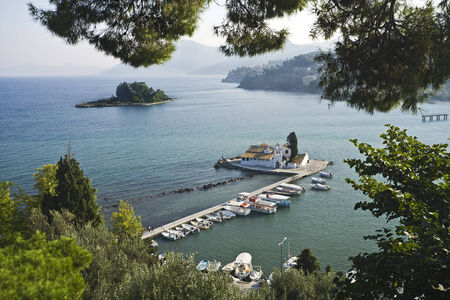 Vlacherna monastery and Pontikonisi, Mouse Island, near Kerkyra, Corfu, Greece, seen through the trees on Kanoni hillsの写真素材