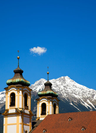 belltowers of Wilten basilica at Innsbruck and the Karwendel mountain rangeの写真素材