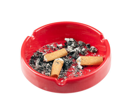 red ashtray containing three cigarette butts and ashes, isolated on whiteの写真素材