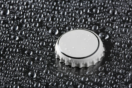 crown cork on metal surface fullof water dropletsの写真素材