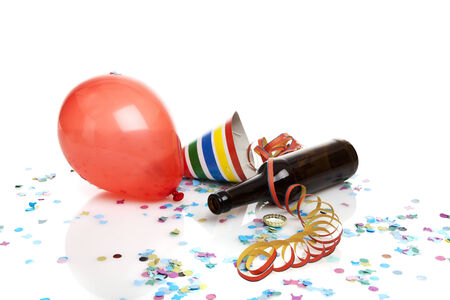 balloon, tilted beer bottle, party hat, streamer and confetti on white backgroundの写真素材