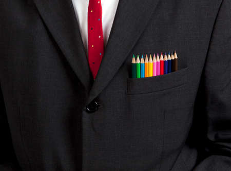 chest of man in business suit with color pencils in his pocketの写真素材