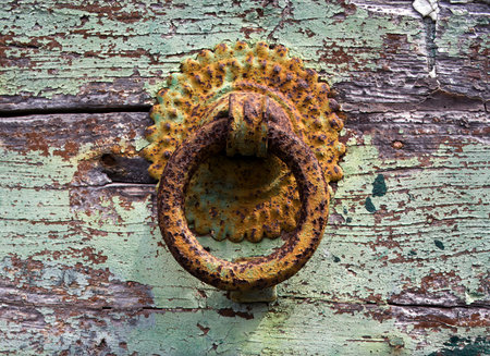 rsuty doorknocker on door with crumbling paintの写真素材