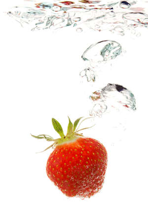 strawberry sinking in water making bubblesの写真素材