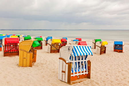 colorful bhooded beach chairs at the baltic seaの写真素材