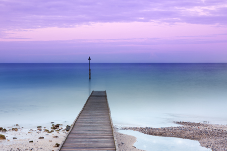 Wooden jetty partially under water, long exposure at duskの写真素材