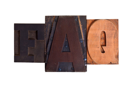Phrase FAQ  in vintage wooden and metal letterpress type, scratched and stained, isolated on whiteの写真素材