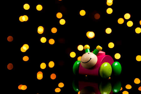 Children's toy - wooden bug with wheels in sparkling lightの写真素材