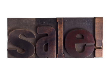 Word sale in vintage wooden letterpress type, scratched and stained, isolated on white backgroundの写真素材