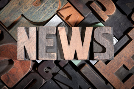 news written with colored vintage letterpress printing blocks on random letters backgroundの写真素材