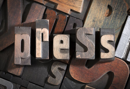 press written with vintage letterpress printing blocks on random letters backgroundの写真素材