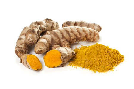 Ground turmeric and turmeric roots isolated on white backgroundの写真素材