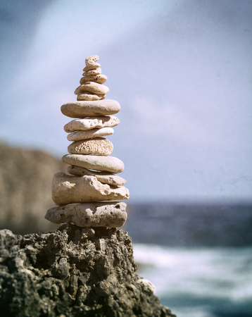 Concept of Balance - Stacked pebbles and fossil corrals at rocky coastの写真素材