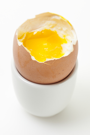 half eaten boiled brown egg in eggcup, high angle viewの写真素材