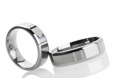 Wedding rings reflecting on white background, tilted viewの写真素材
