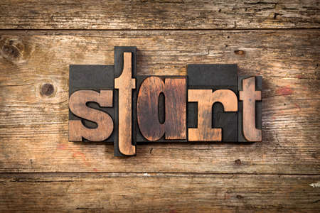 word START, set with letterpress type on rustic wooden backgroundの写真素材