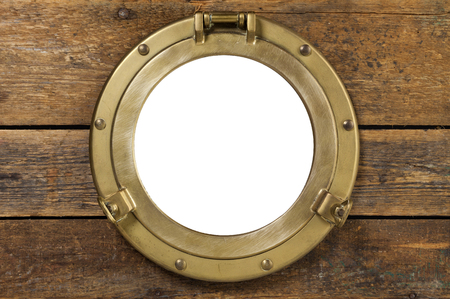 old brass porthole in wooden wall, window isolated with clipping pathの写真素材