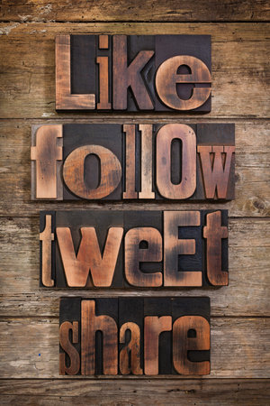 like, share, tweet, follow, social media tags set with antique letterpress type on rustic wooden backgroundの写真素材