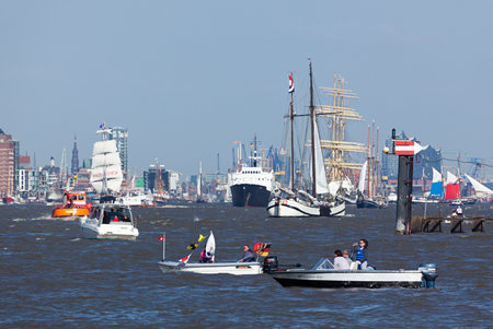 Sailing ships and other vessels at departure parade of 827th Hamburg Port Anniversary, small boats with spectators in foreground.のeditorial素材