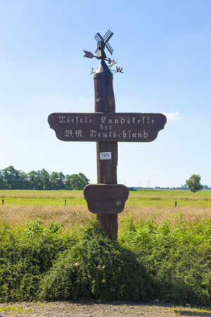 Wooden sign marking the lowest accessible point in Germany, 3.54 meters below mean sea level, at Neuendorf-Sachsenbande, Schleswig-Holstein.の写真素材
