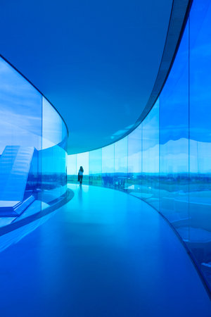 Aarhus, Denmark - May 2, 2017: A young woman walks through the blue tinted area of an installation by Danish-Icelandic artist Olafur Eliasson on rooftop of ARoS art museum.のeditorial素材