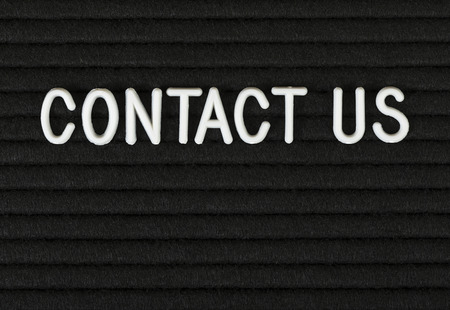 Contact us, phrase written with white plastic letters on felt message boardの写真素材