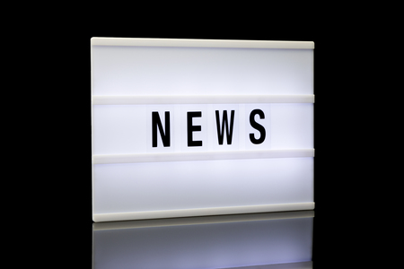NEWS written on lightbox reflected on black backgroundの写真素材