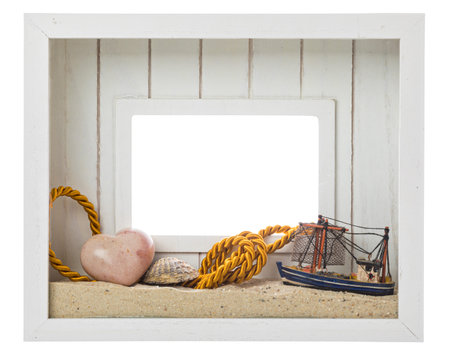 Seaside and beach souvenirs. Wooden white picture frame decorated with sand, sea shell, heart-shaped...