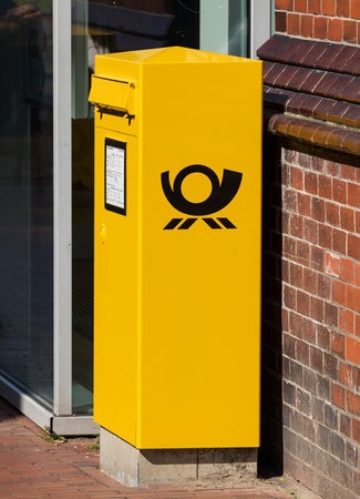 Stade, Germany - August 22, 2019: Yellow letterbox with German Post logo