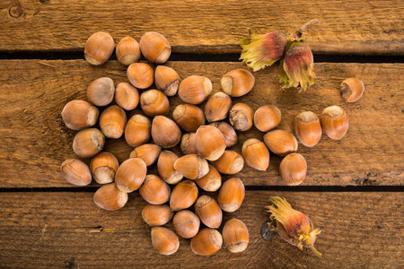 Freshly harvested hazelnuts,  some with husks, on rustic wooden background