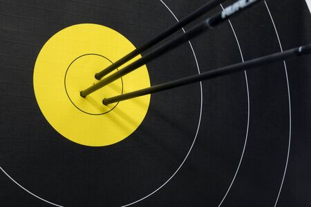Three arrows in the center of black and yellow archery target. Accuracy and precision concept.の写真素材