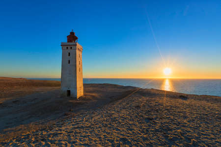 The famous lighthouse of Rubjerg Knude, Denmar, at sunsetの写真素材