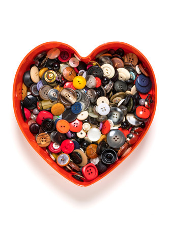 Heart shaped plastic box filled with buttons, top view, isolated on white background