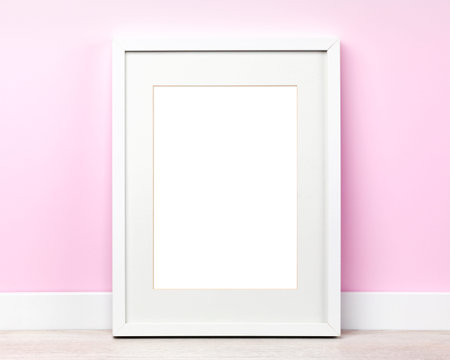 Poster mockup with white picture frameleaning on pink wall. Artwork template, blank area isolated...