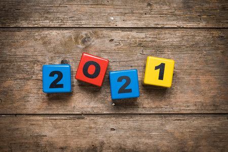 Year 2021 set with toy number blocks on rustic wooden background