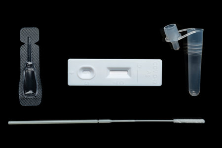 All parts of sars-cov-2 rapid antigen test kit on black surface flat lay