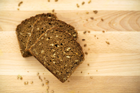Three slices of whole grain brown bread fanned out, high angle view, copy space