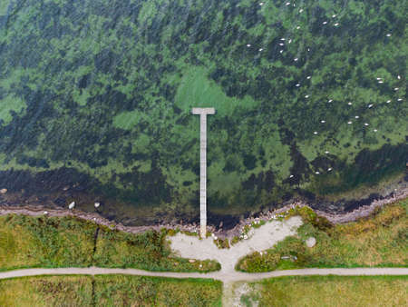 Wooden jetty and small beach at Baltic Sea coast of Danish island Lolland, aerial viewの写真素材