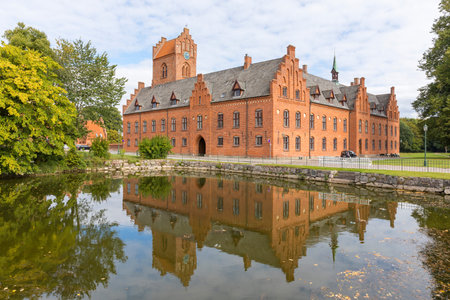 Historic church and monastery buildings at Herlufsholm reflected in a basin