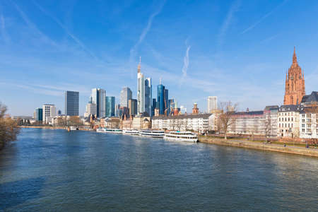 City of Frankfurt with high rises and cathedral, Main river with tourist boats in foregrondの写真素材