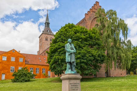 Monument from 1888 for the Danish author Hans Christian Andersen. Odense cathedral in background.の写真素材