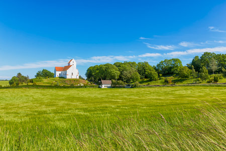 Church and cemetery of Humble with green field in foreground, Langeland island, Denmarkの写真素材
