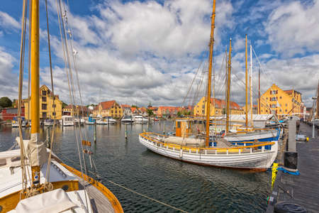 Marina with historic sailboats at the harbor of Svendborg, Funen island, Denmark. Yellow warehouses in background.の写真素材